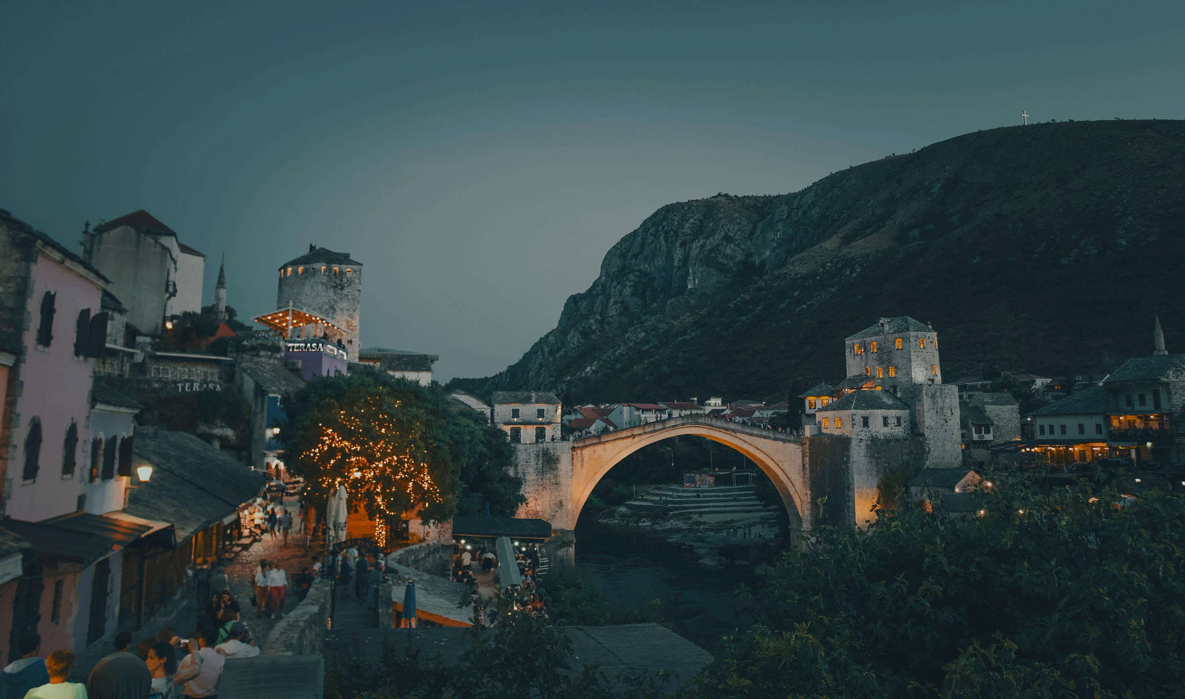 Mostar's Ottoman old bridge over the Neretva at dusk.
